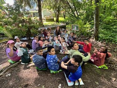 Classroom sit within a forested trail to learn about Indigenous Plants and Animals in the area